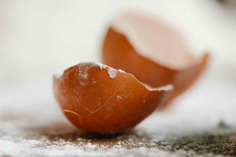 a broken egg sitting on top of a table, by Sylvia Wishart, trending on pexels, brown resin, covered in salt, close up shots, thumbnail