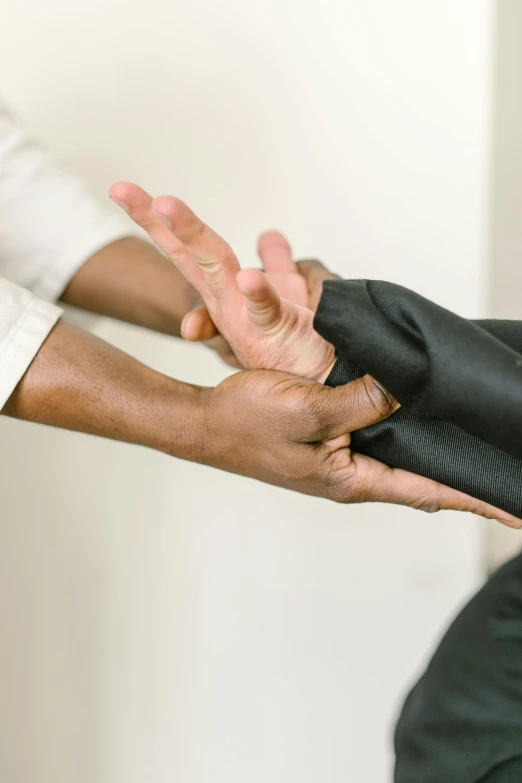 a close up of a person putting something in another person's hand, tailored clothing, up to the elbow, protective, stretching to walls