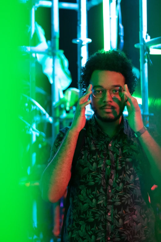 a man holding a cell phone to his ear, an album cover, inspired by Afewerk Tekle, pexels, green lights, looking straight, keyboardist, hyper-real