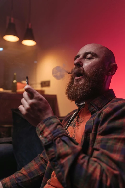 a man sitting on a couch smoking a cigarette, pexels contest winner, renaissance, beard stubble, in a nightclub, picture of a male biker, bald man