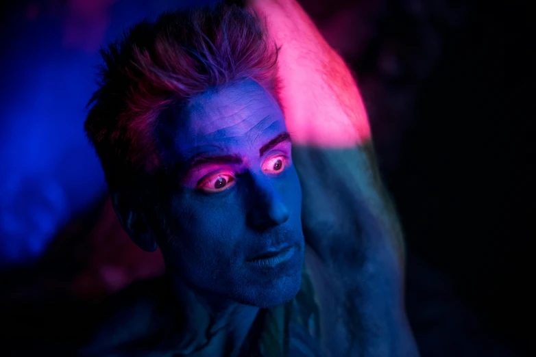 a close up of a person with blue makeup, inspired by David LaChapelle, pexels contest winner, he is casting a lighting spell, justin hartley as superman, muted deep neon color, with haunted eyes and crazy hair
