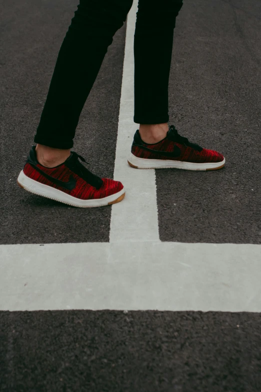 a person standing in the middle of a crosswalk, an album cover, by Adam Marczyński, pexels contest winner, hurufiyya, sneaker made out of lego, maroon red, vehicle, profile image