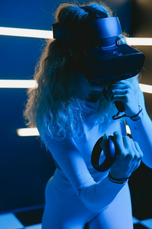 a woman standing in front of a black and white checkered floor, a hologram, interactive art, sleek oled blue visor for eyes, using a vr headset, with a blue background, photograph of a techwear woman