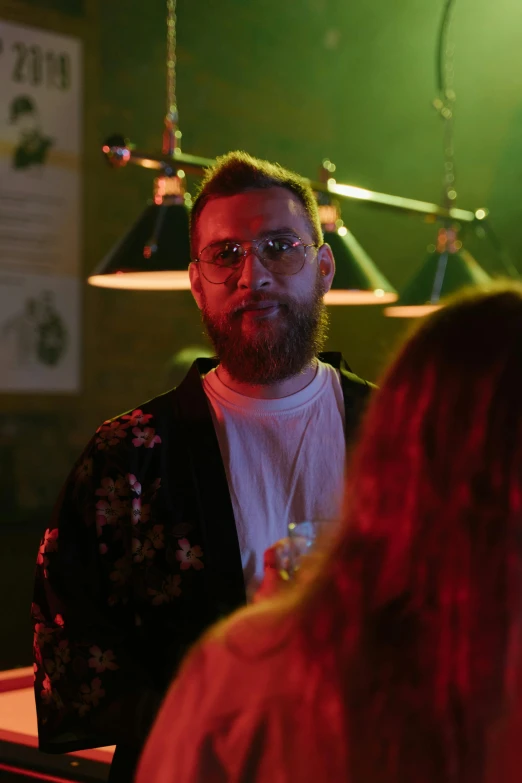 a man standing next to a woman at a bar, happening, ginger bearded man with glasses, music video, lgbtq, artem chebokha