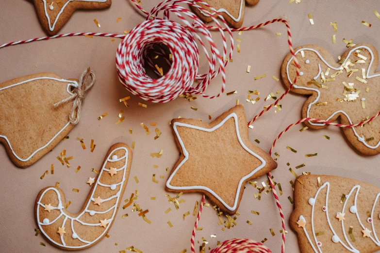 a spool of twine of twine of twine of twine of twine of twine of twine of twine of, by Sylvia Wishart, trending on pexels, gingerbread people, glittering stars scattered about, baking cookies, orange ribbons