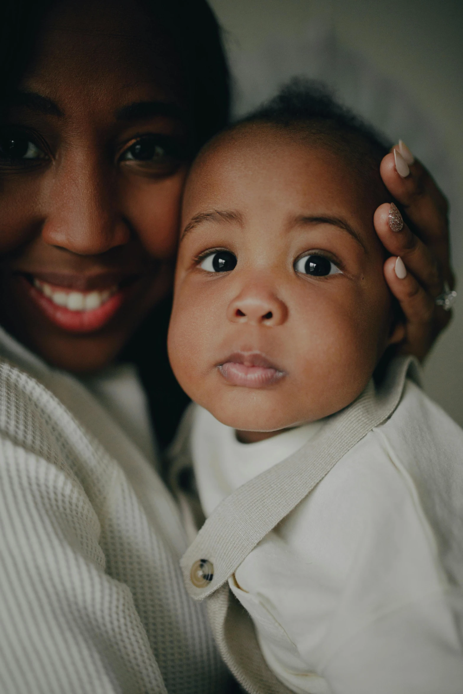 a woman holding a baby in her arms, inspired by Gordon Parks, unsplash, portrait closeup, full frame image, beatifully lit, multiple stories