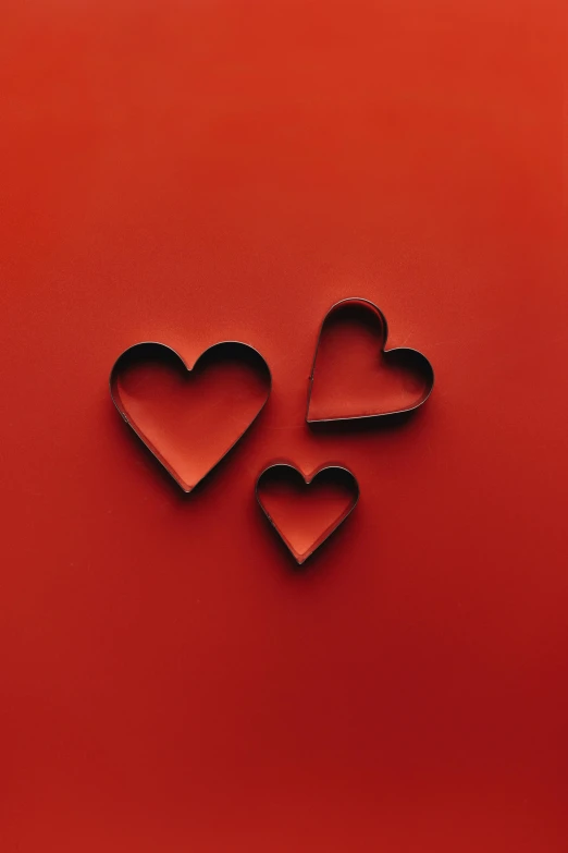 three hearts cut out of paper on a red background, pexels contest winner, red iron oxide, 256435456k film, thomas kinkad, made of rubber