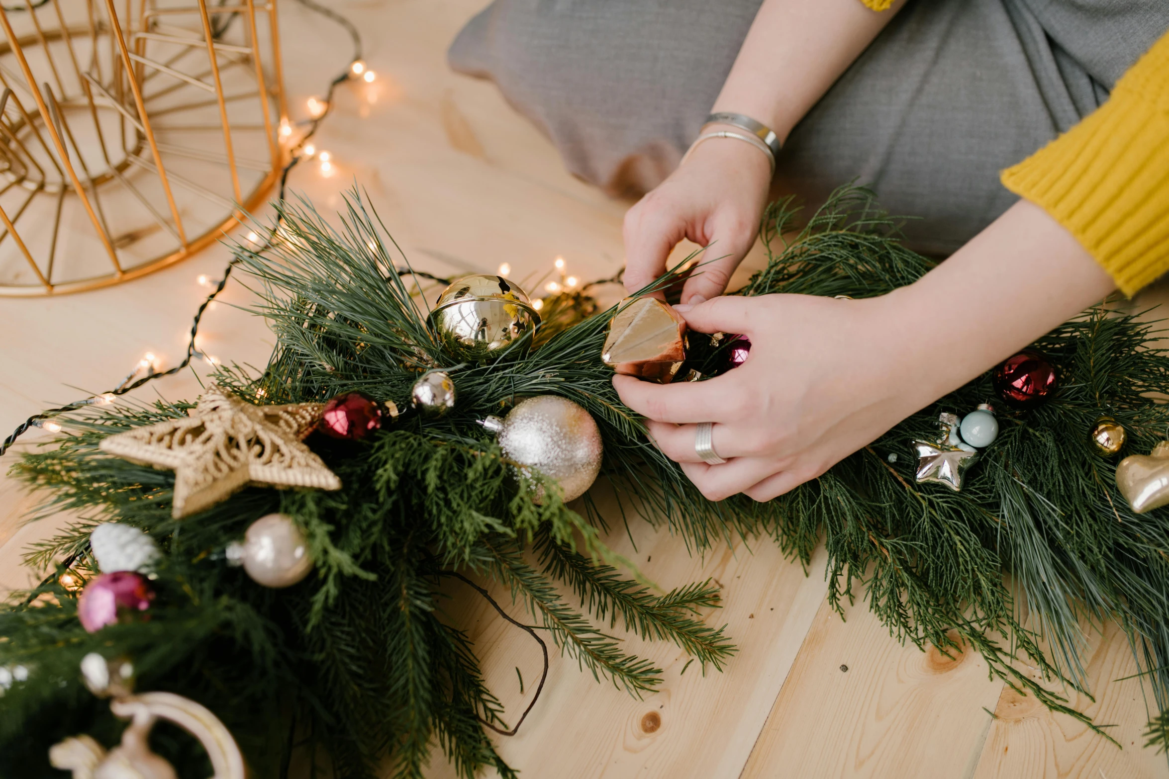 a woman decorating a christmas wreath on a wooden floor, by Julia Pishtar, trending on pexels, stitching, multiple stories, transparent background, cardboard