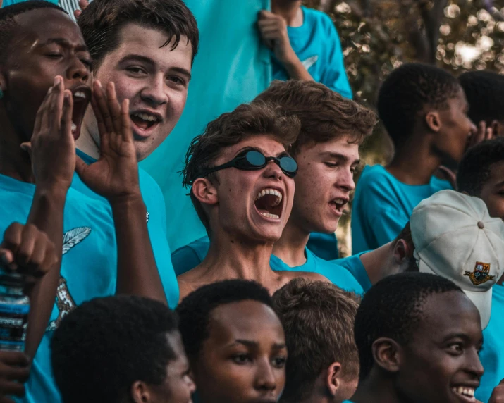 a group of young men standing next to each other, by Sam Dillemans, pexels contest winner, happening, he is screaming, teal uniform, gofl course and swimming, below is the crowd