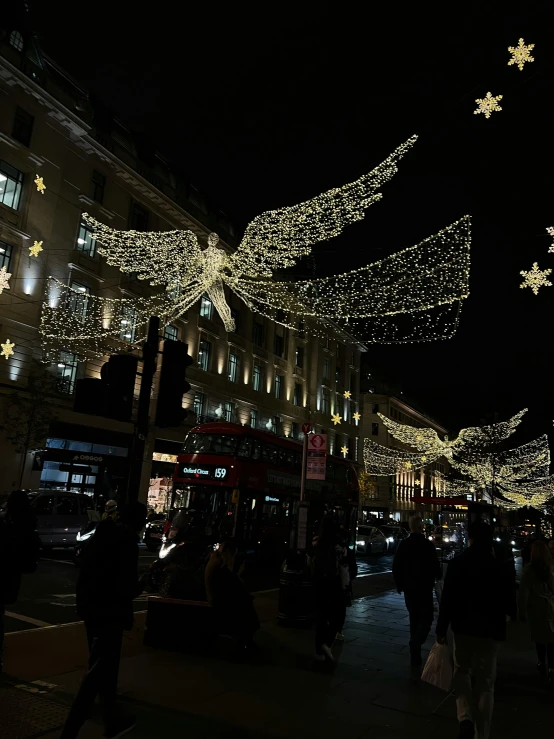 a group of people walking down a street at night, decorations, thumbnail, in london, angels