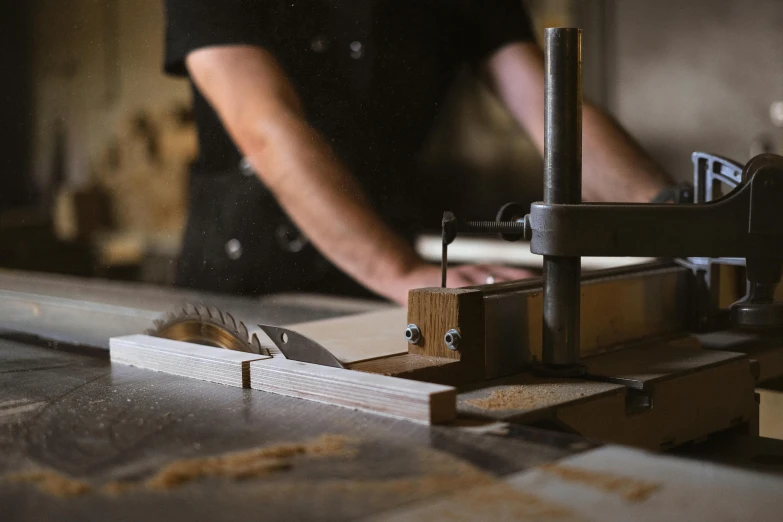 a close up of a person cutting a piece of wood, pexels contest winner, arts and crafts movement, frank moth, wooden tables, saws, profile image