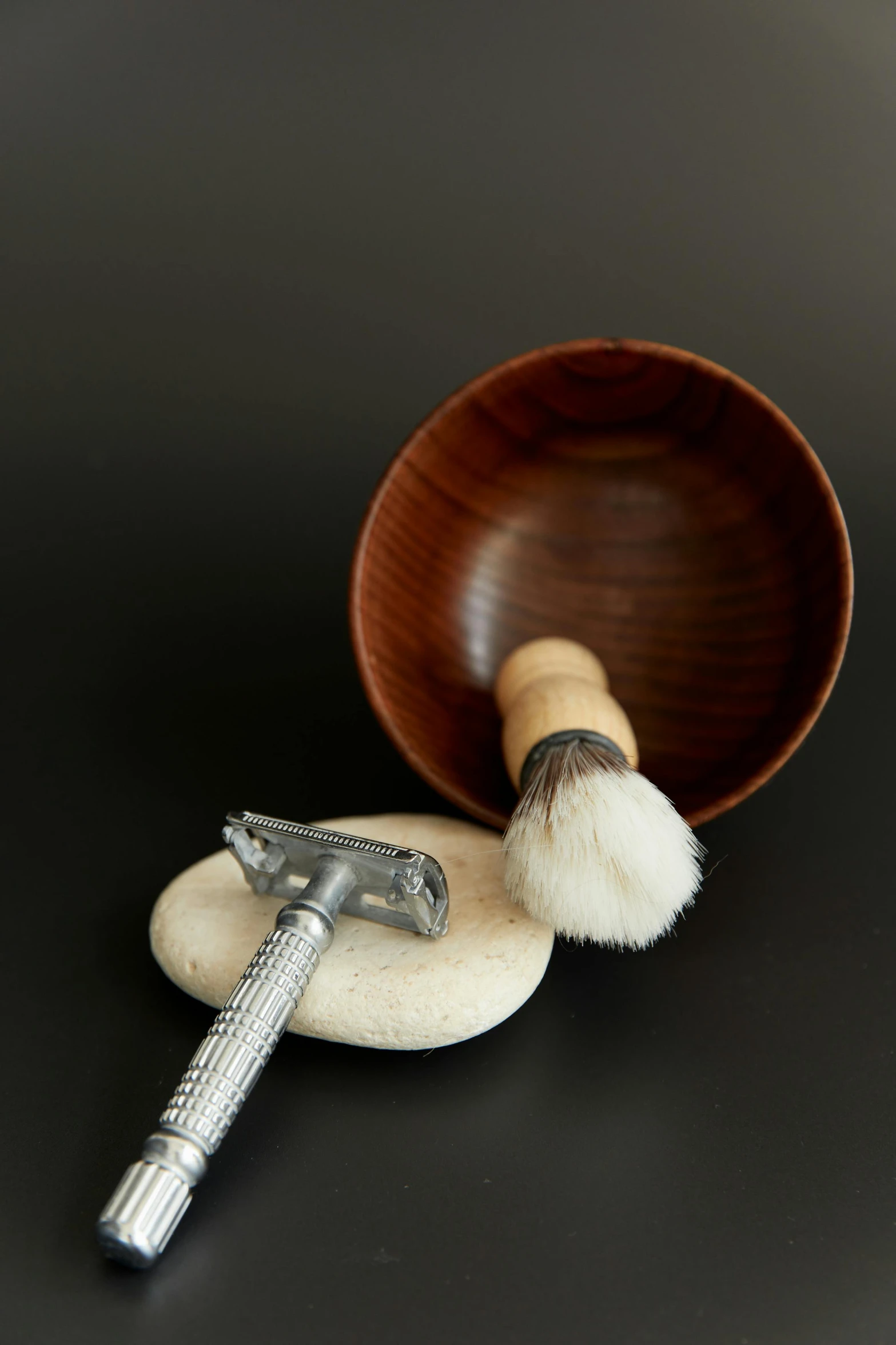 a shaving brush sitting on top of a wooden bowl, inspired by Wilhelm Hammershøi, renaissance, with axe, mixed materials, 9 0 mm, sleek hands