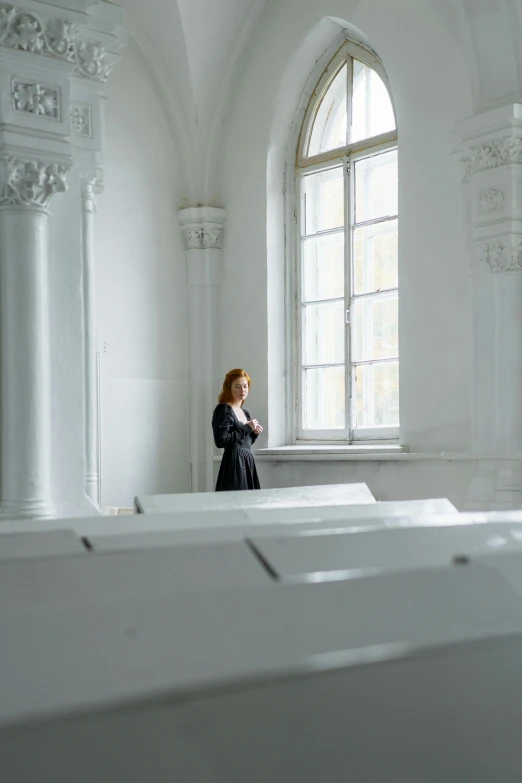 a woman standing in the middle of a room, inspired by Anna Füssli, neoclassicism, white church background, pondering, trending photo, white