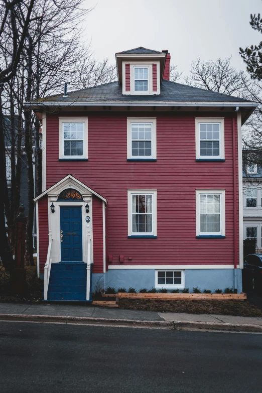 a red house with a blue door and windows, a colorized photo, by Carey Morris, pexels contest winner, magenta and gray, ballard, new england architecture, unsplash photo contest winner