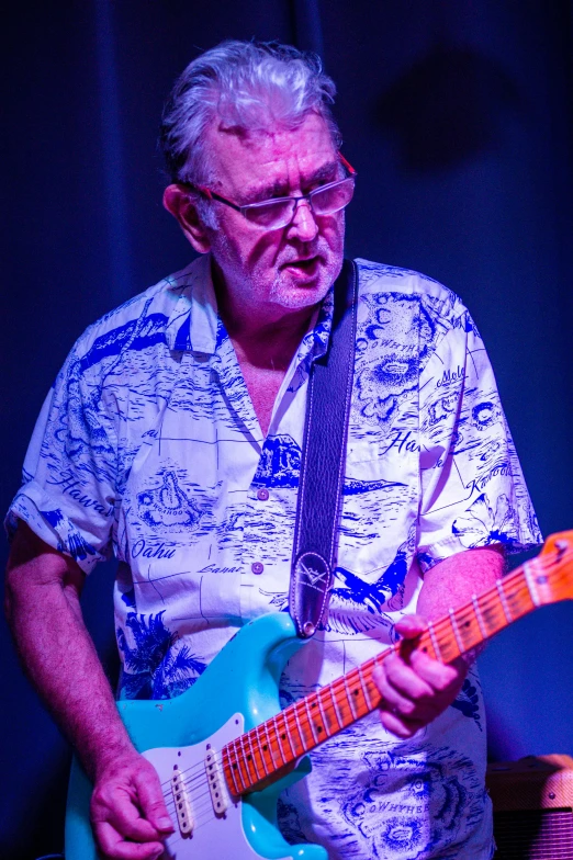 a man playing an electric guitar on stage, a portrait, by Dave Melvin, greens and blues, smug look, multi - coloured, old man