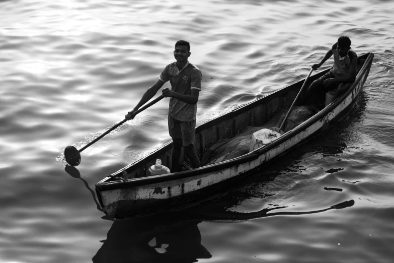 a black and white photo of two people in a boat, a black and white photo, by Alexander Runciman, pexels contest winner, fish man, india, early evening, one man