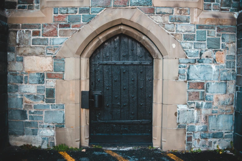 a black door sitting inside of a stone building, by Carey Morris, unsplash, romanesque, brown, gothic revival, background image, churches