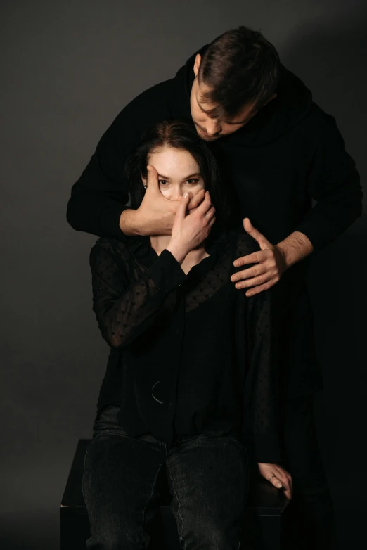 a man and a woman sitting next to each other, a portrait, unsplash, antipodeans, hugging her knees, wrapped in black, woman holding another woman, mouth shut