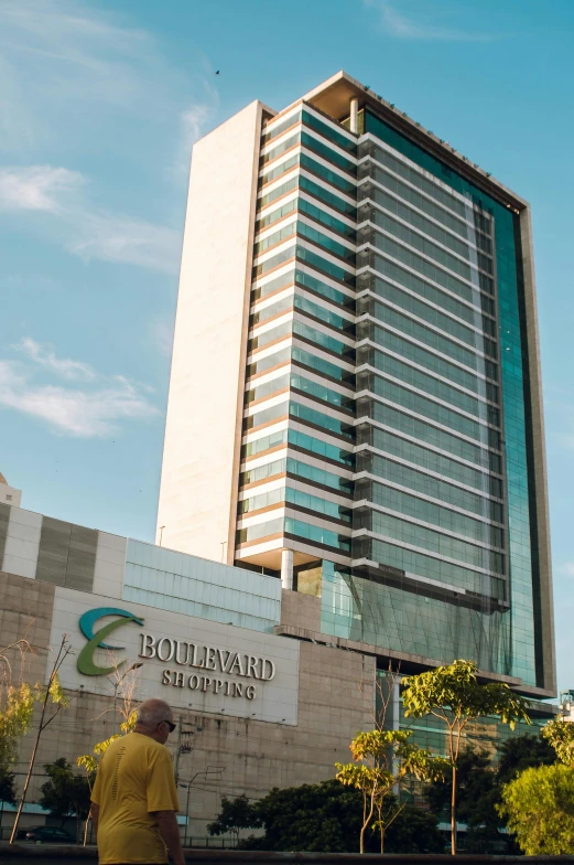 a man standing in front of a tall building, bolsonaro, gilleard, business logo, boulevard