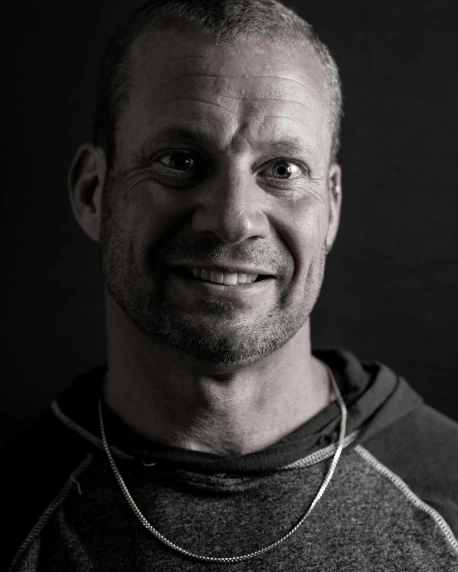 a black and white photo of a man smiling, inspired by Frank Buchser, unsplash, muscular men entwined together, phil spencer, halfbody headshot, taken in the late 2010s