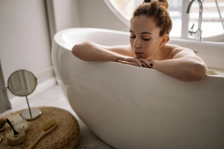 a woman sitting in a bathtub with her eyes closed, trending on pexels, curved, pondering, maternity feeling, candy treatments