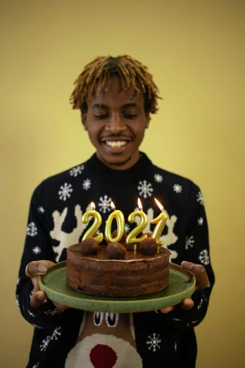 a man holding a cake with candles on it, an album cover, trending on unsplash, 2022 picture of the year, youthful taliyah, he is at college, ap news photo