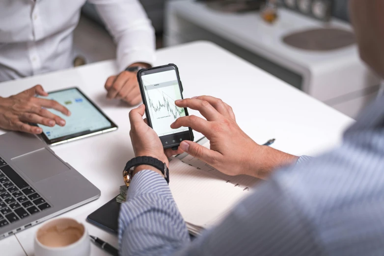 a couple of men sitting at a table with laptops, a picture, trending on pexels, analytical art, corporate phone app icon, 9 9 designs, holds a smart phone in one hand, digital medical equipment