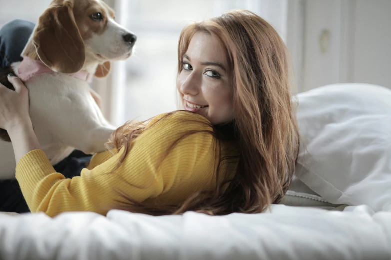 a woman laying on a bed holding a dog, pexels contest winner, cute young redhead girl, looking across the shoulder, australian, yellow