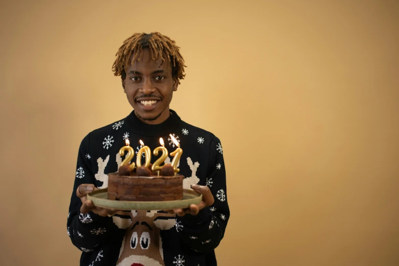 a man holding a cake with candles on it, pexels contest winner, hyperrealism, lil uzi vert, wearing festive clothing, 21 years old, extremely happy