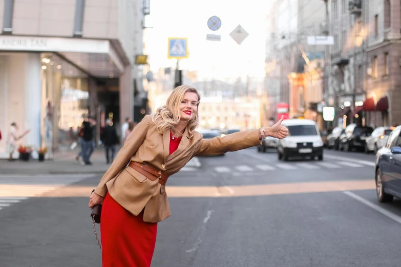 a woman in a red dress on a city street, by Emma Andijewska, pexels contest winner, happening, light brown trenchcoat, excited russians, 🦩🪐🐞👩🏻🦳, a blond