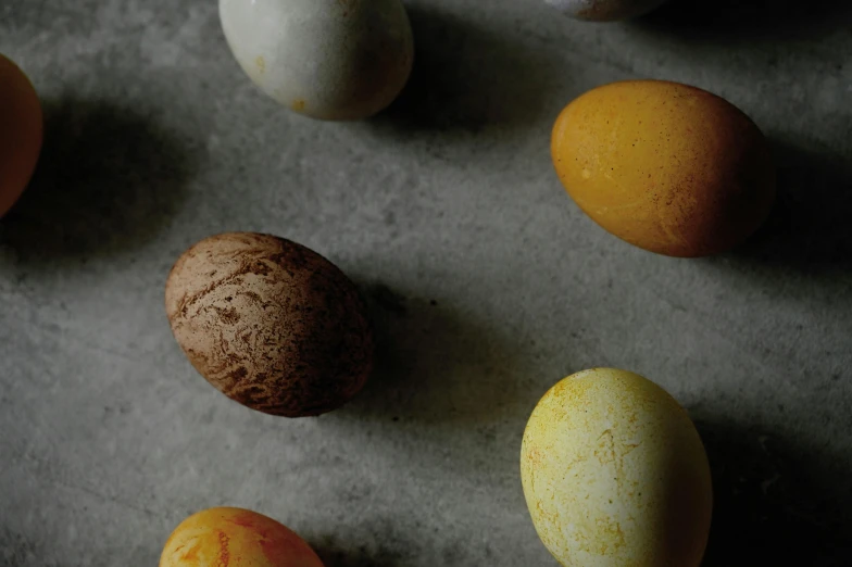 a table topped with lots of different colored eggs, unsplash, photorealism, on grey background, ochre, high-resolution photo, multiple stories