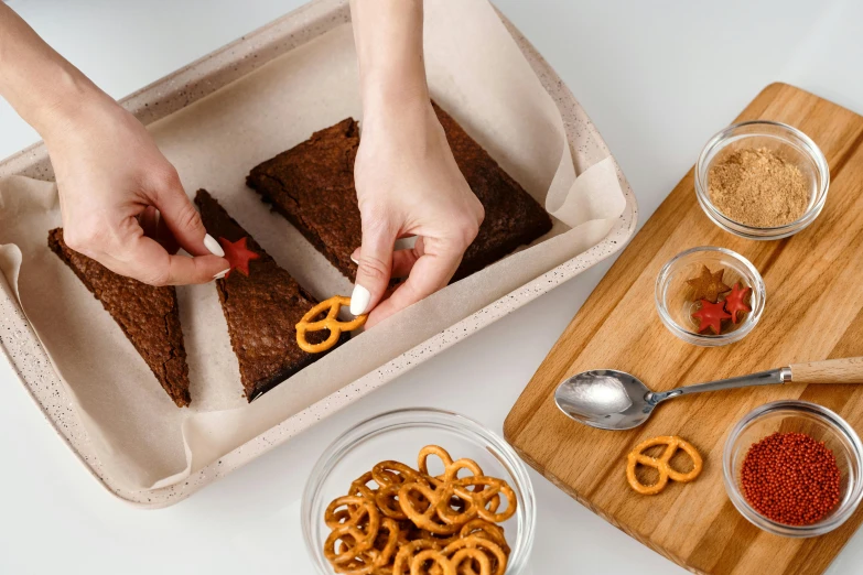 a person cutting a piece of cake with pretzels, textured base ; product photos, smokey burnt envelopes, thumbnail, brown resin