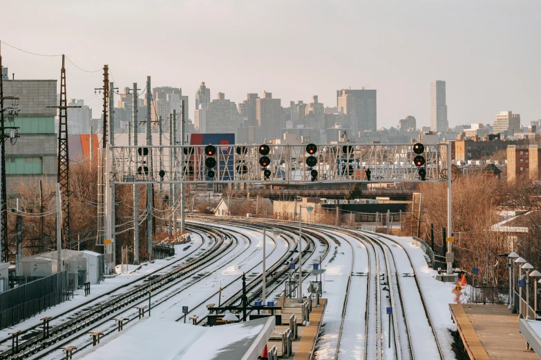 a train traveling down train tracks next to a city, by Carey Morris, new - york skyline in winter, trading depots, unsplash photography, 2000s photo