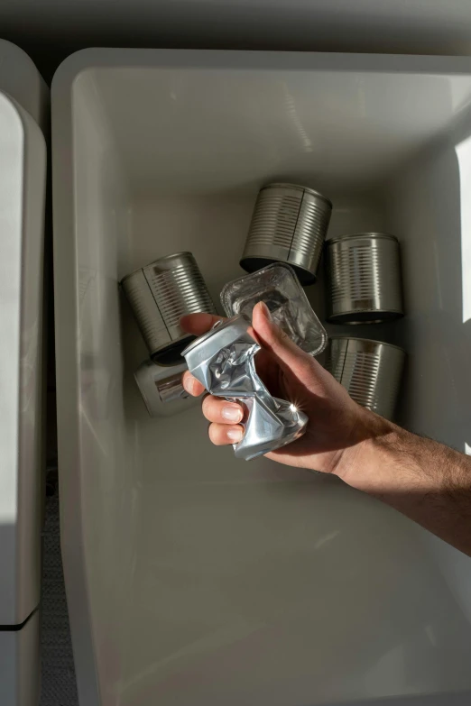 a person holding a can in front of a sink, set pieces, shiny silver, 6 pack, emergency countermeasures