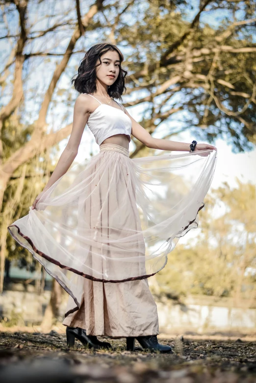 a woman that is standing in the grass, a picture, by Basuki Abdullah, pexels contest winner, arabesque, wearing a tanktop and skirt, wearing organza gown, wearing crop top and miniskirt, ad image