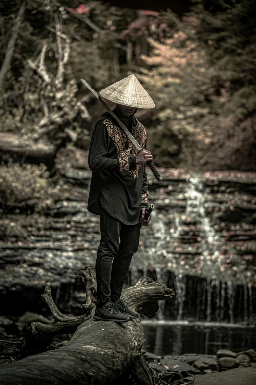 a man standing on top of a log next to a river, an album cover, inspired by Kanō Hōgai, pexels contest winner, afrofuturism, samurai outfit, black, portrait shot, vietnam war soldier