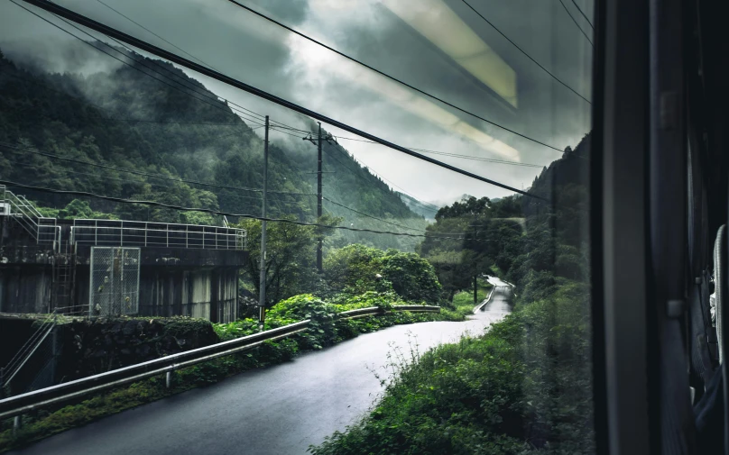 a view of a road through a window of a train, inspired by Thomas Struth, sōsaku hanga, lush valley, full of clear glass facades, desaturated, in glass town