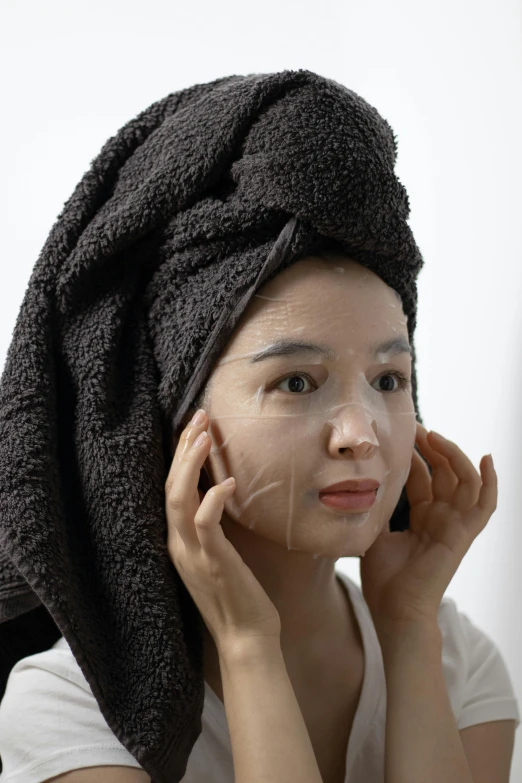 a woman with a towel wrapped around her head, by Sengai, reddit, silicone skin, detailed product image, portrait mode photo, black