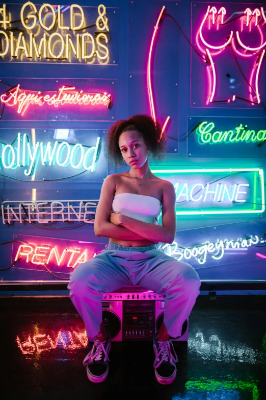 a woman sitting on a bench in front of neon signs, trending on pexels, renaissance, nathalie emmanuel, studio lights, posed, teenage vanessa morgan