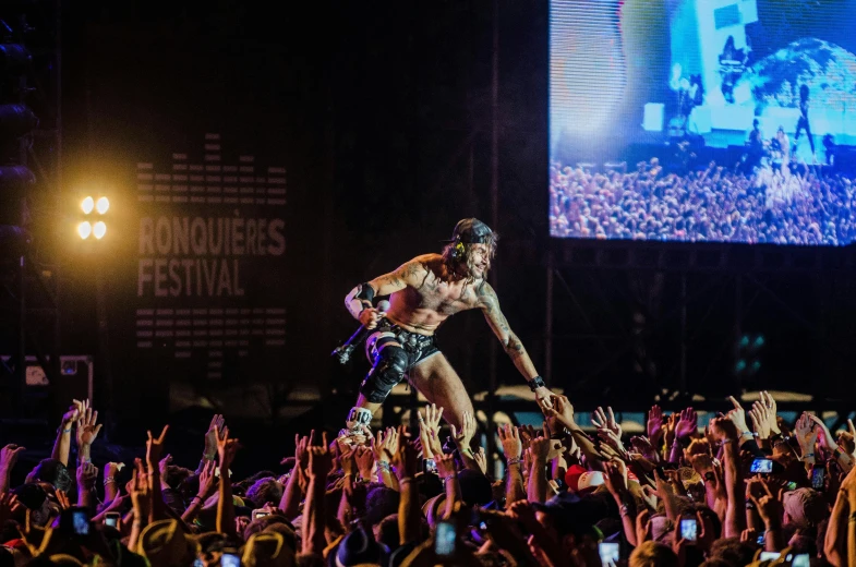 a man standing on top of a motorcycle in front of a crowd, pexels contest winner, baroque, zyzz, rapping on stage at festival, set on singaporean aesthetic, wearing loincloth