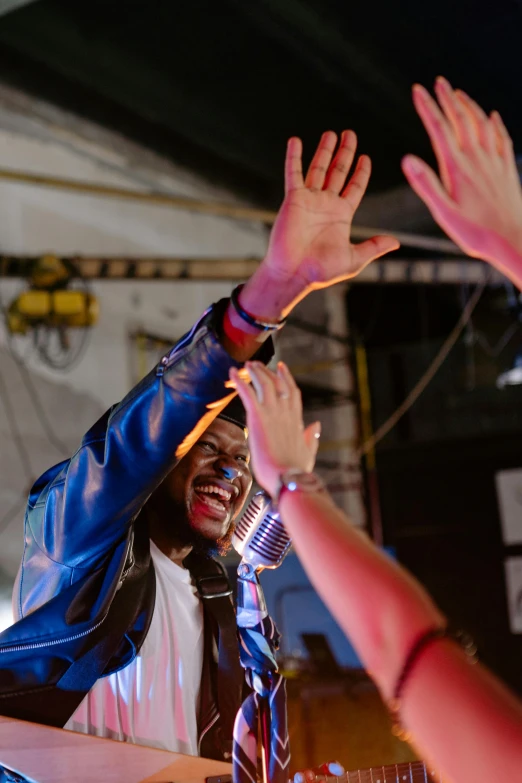 a group of people standing on top of a stage, an album cover, pexels, happening, holding his hands up to his face, dj at a party, mrbeast, medium closeup