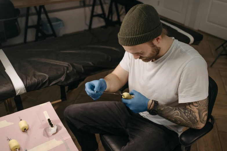 a man sitting on a chair in a room, by Ryan Pancoast, pexels contest winner, hyperrealism, small vials and pouches on belt, coating a stubborn core.', temporary tattoo, thumbnail