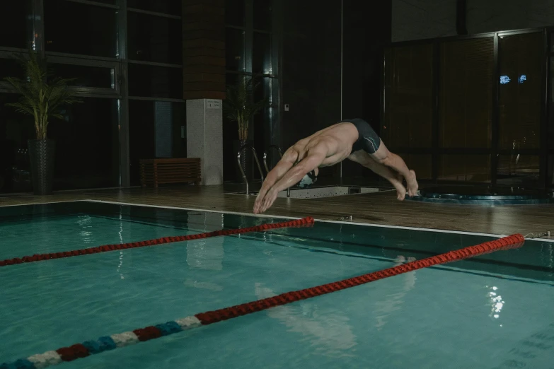 a man doing a handstand in a swimming pool, by Emma Andijewska, origin jumpworks, indoor shot, low quality photo, thumbnail