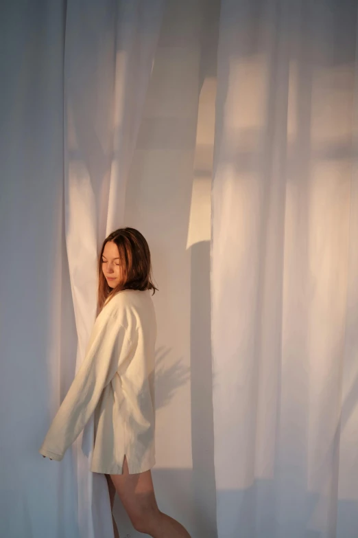 a woman standing in front of a curtain, inspired by Fei Danxu, unsplash, light and space, bathrobe, nishihara isao, soft volumetric studio lighting, hwang se - on