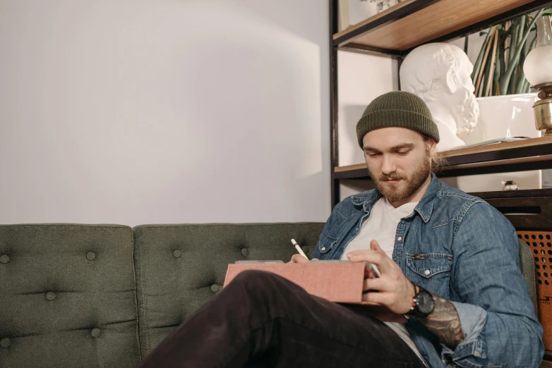 a man sitting on a couch reading a book, a drawing, inspired by Seb McKinnon, trending on pexels, writing on a clipboard, portrait shot, thumbnail, casually dressed