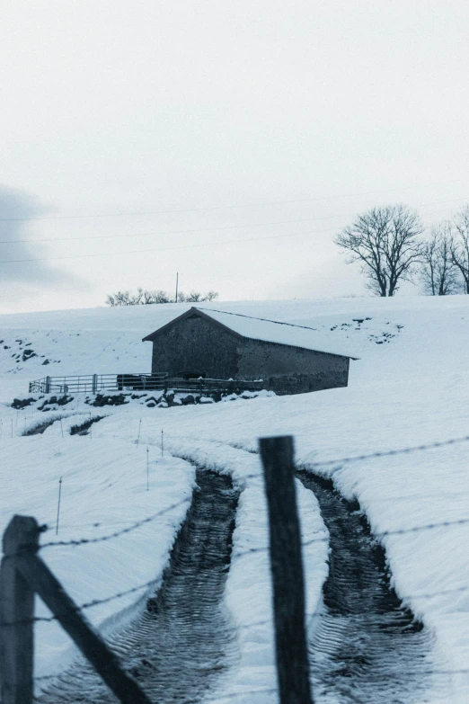 a snow covered field with a barn in the distance, an album cover, inspired by Peter Zumthor, pexels contest winner, photo of zurich, today\'s featured photograph 4k, crewdson, hillside