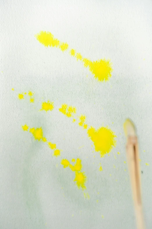 a close up of a toothpick with yellow paint on it, a watercolor painting, arbeitsrat für kunst, sparse floating particles, with a bright yellow aureola, holding paintbrushes, animation still