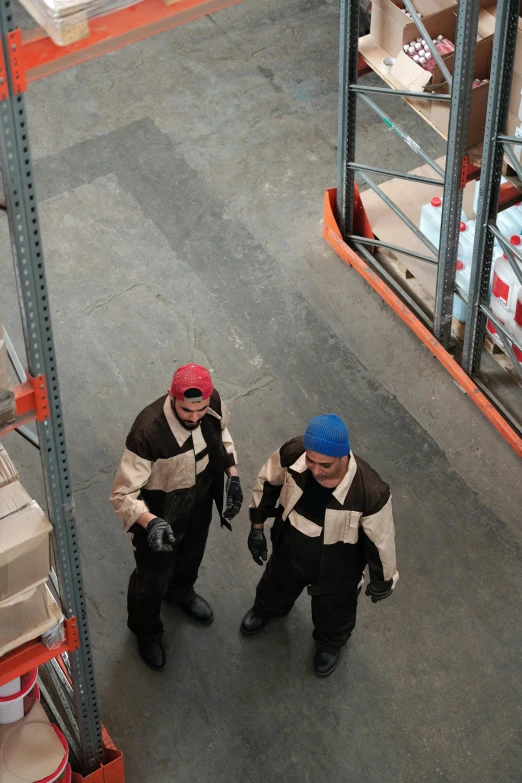 a couple of men standing next to each other in a warehouse, pexels contest winner, renaissance, birdseye view, working clothes, low quality photo, screensaver