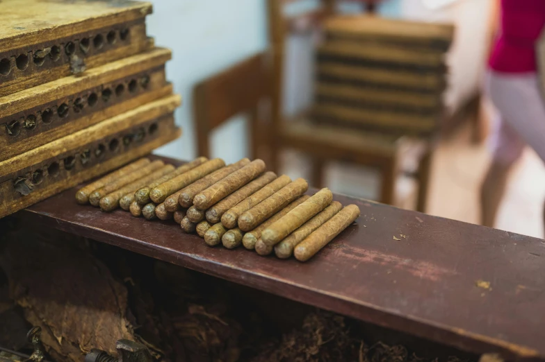 a pile of cigars sitting on top of a wooden table, multiple stories, thumbnail, cuba, high quality product image”