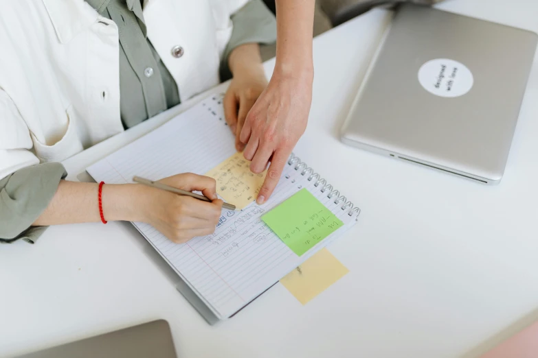 a woman sitting at a desk writing on a piece of paper, trending on pexels, ink on post it note, planner stickers, thumbnail, low quality photo